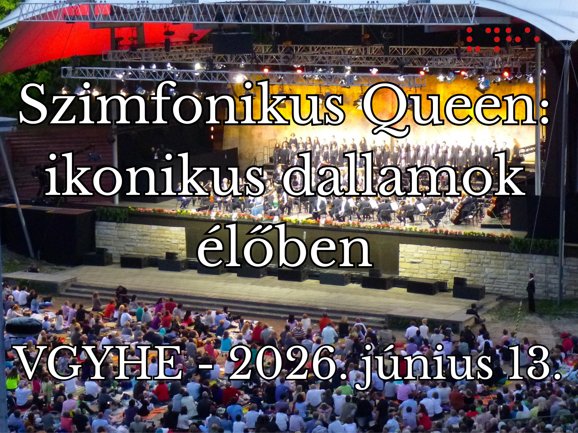 A képen egy szabadtéri koncerthelyszín látható, ahol egy szimfonikus zenekar és kórus lép fel, sok hangszerrel a színpadon. A nézőtéren nagy tömegnyi ember élvezi az előadást.